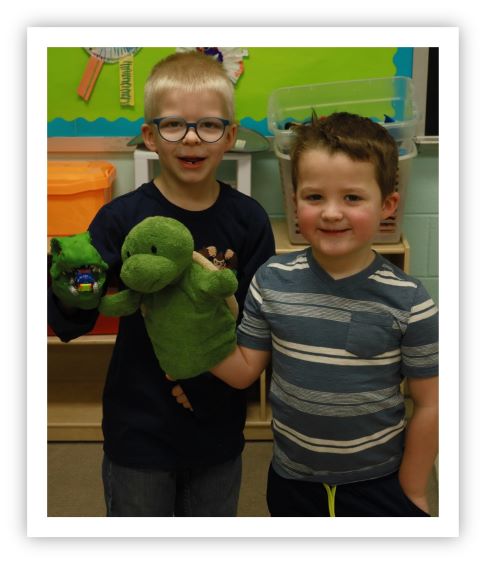 2 preschoolers laughing in the classroom